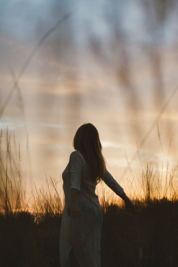 Crafting Captivating Headlines: Your awesome post title goes here A serene silhouette of a woman in a meadow at sunset, embracing moment of freedom.
